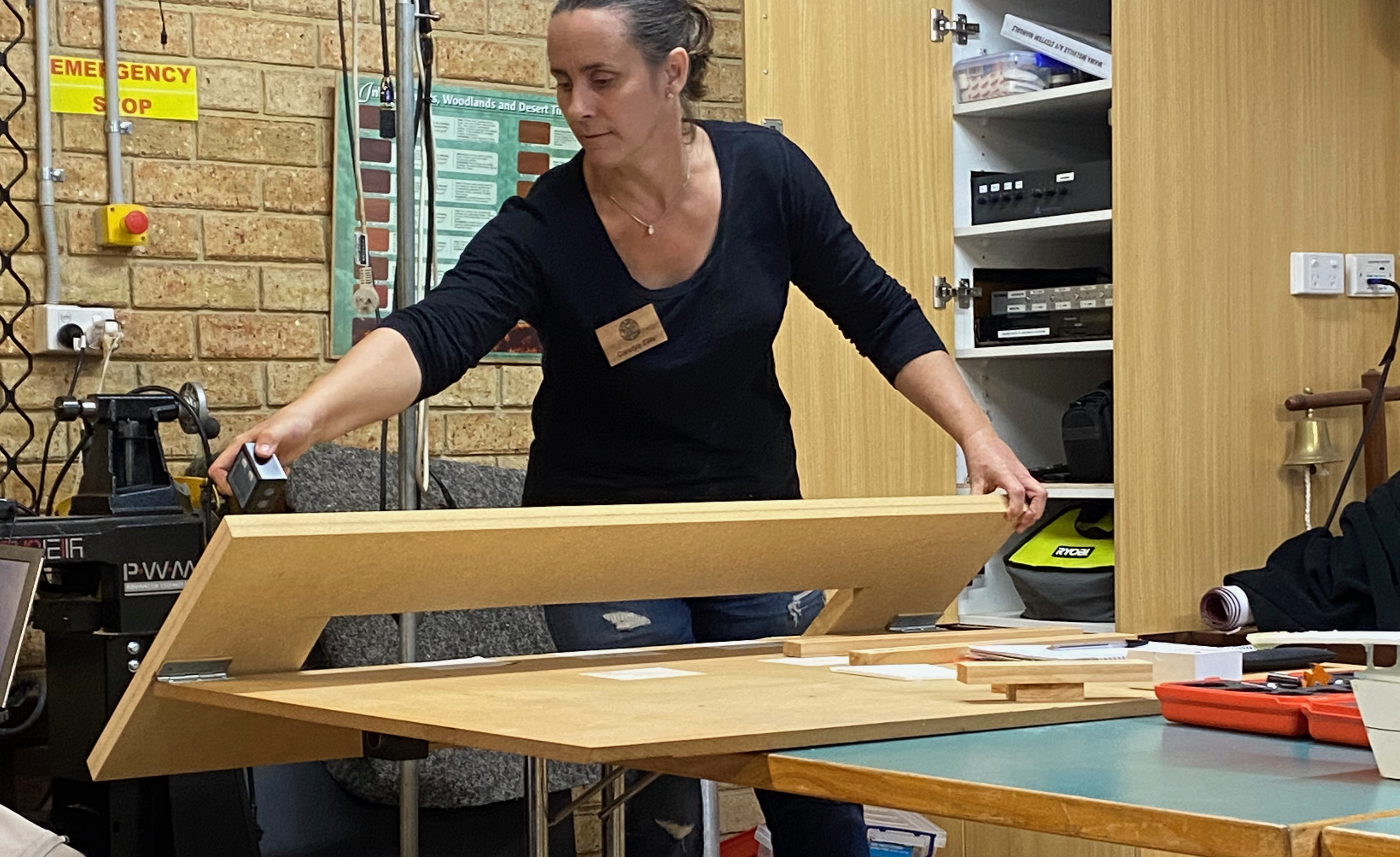 Photo of Carolyn demonstrating the jig used to make mitred corners