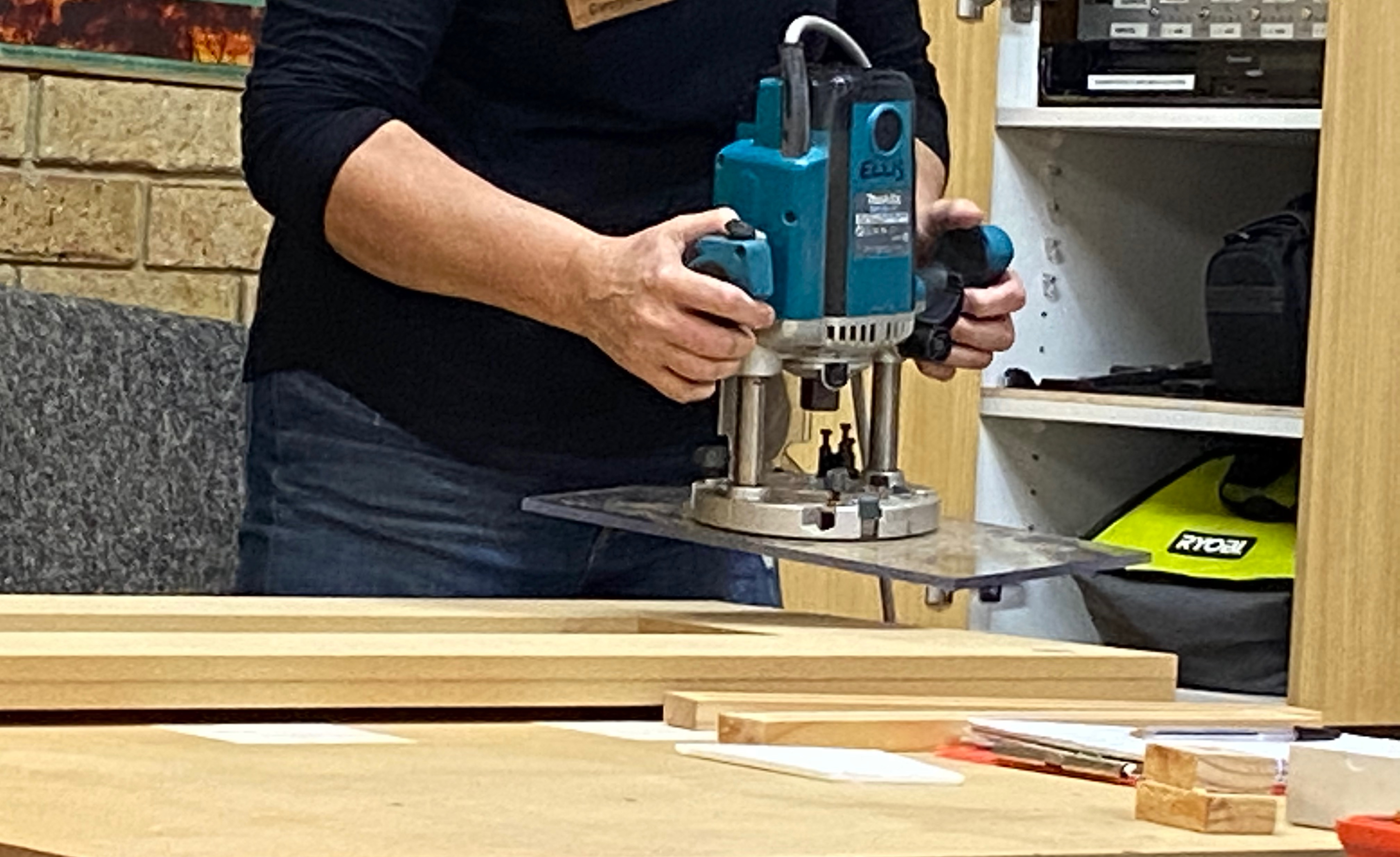 Photo of Carolyn demonstrating how to use a router with the joinery jig