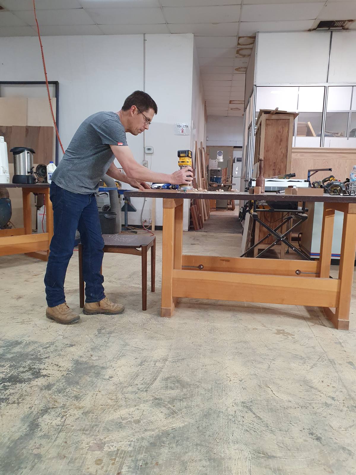 Photo of David using trim router to round over edge.