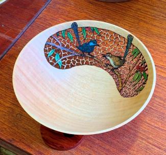 Photo of a small bowl featuring two birds on branches. The birds are incorporated into a pierced section of the bowl where the creator has removed small sections of the bowl's wall to produce an open pattern