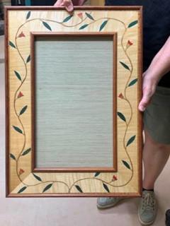 Photo of the frame that Ian made showing the inlaid vine with green and red leaves